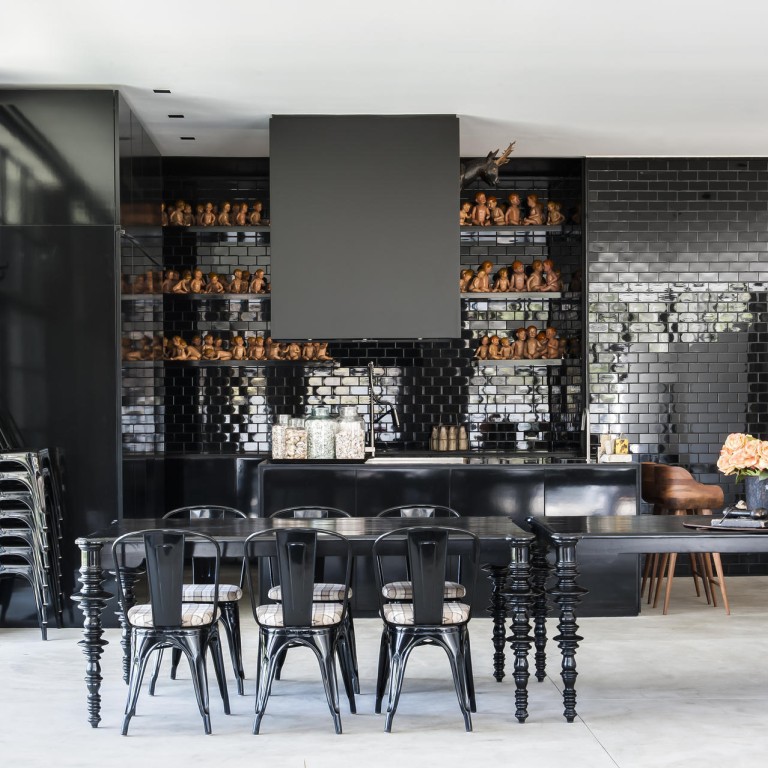 In the kitchen, a large collection of vintage dolls is displayed on the shelves, arranged so that they seem to interact with each other.