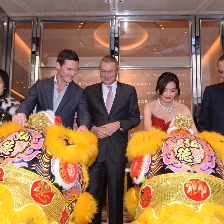 Luke Evans looks on with enthusiasm as Shu Qi dots her lion's eyes