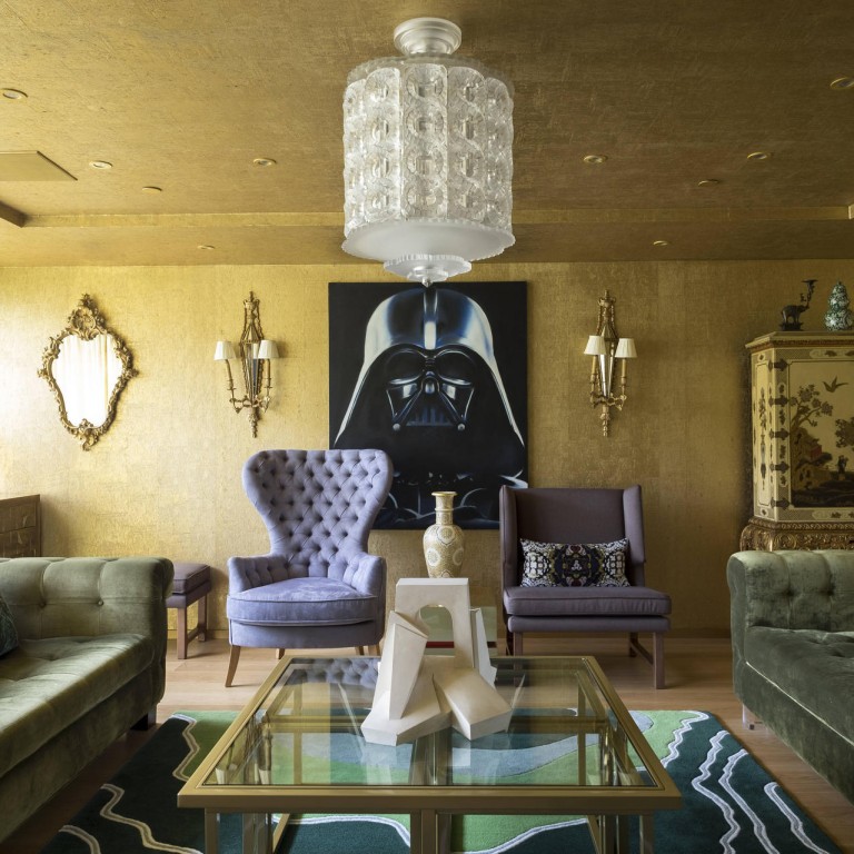 The golden living room features eclectic lights, plush green sofas and luscious purple chairs. A big bold portrait of Darth Vader hangs on the wall and a Chinese-style cabinet sits in the corner. Photography: James Merrell