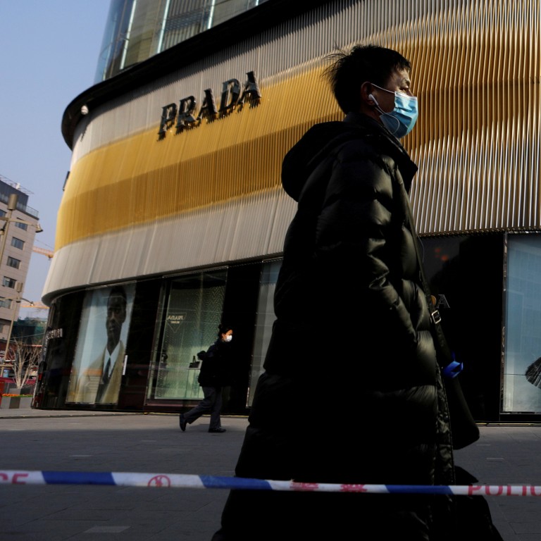 A man walks past a Prada store in Beijing, the city that according to Forbes now has the greatest number of billionaires on the planet. Photo: Reuters
