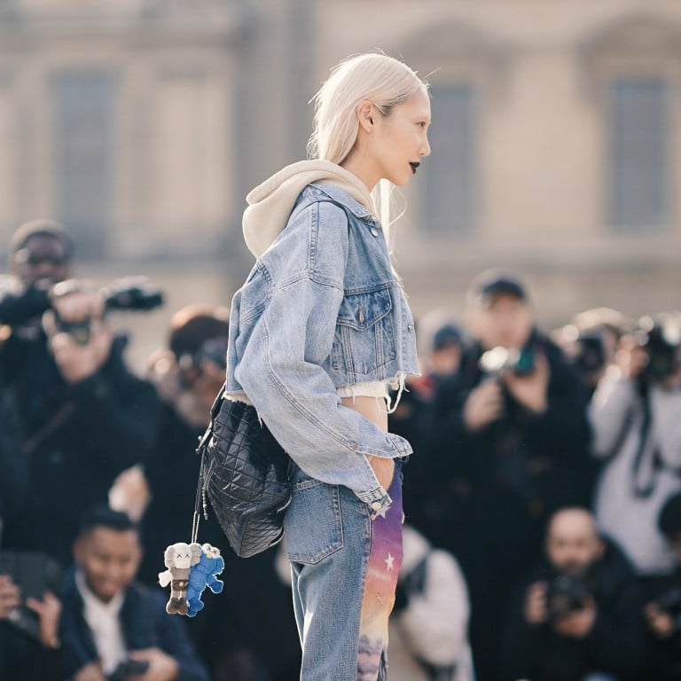 Soo Joo Park wears a blue denim jacket, a cropped hoodie sweater, a white cropped top, purple “Europe” pants outside Off-White during Paris Fashion Week in Paris, France. Photo: Getty Images