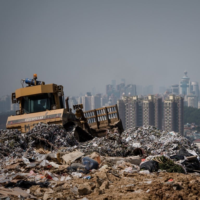 This picture taken on March 6, 2013 shows a landfill in the new territories of Hong Kong as the Chinese city of Shenzhen looms in the background.  Official data shows that the city generates about 19,000 tonnes of solid waste every day, with 9,100 tonnes dumped into landfills -- two thirds of it domestic waste. Only 52 percent of total waste is recycled in a city that produces an average of 921 kilograms of rubbish per person per year, which is more than twice the amount compared to Japan (410kg) and South Korea (380kg), according to the Organisation for Economic Cooperation and Development.  AFP PHOTO / Philippe Lopez (Photo by Philippe LOPEZ / AFP)