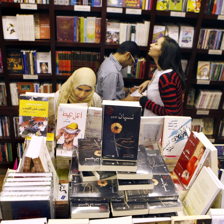 Egyptians crowd around novels by young authors at the Cairo Book fair. File photo: AP