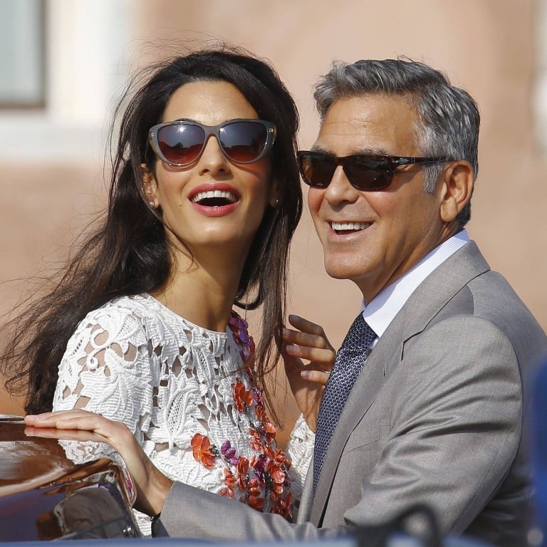US actor George Clooney and his wife Amal Clooney stand in a water taxi on the Grand Canal in Venice, in September 2014. Photo: Reuters