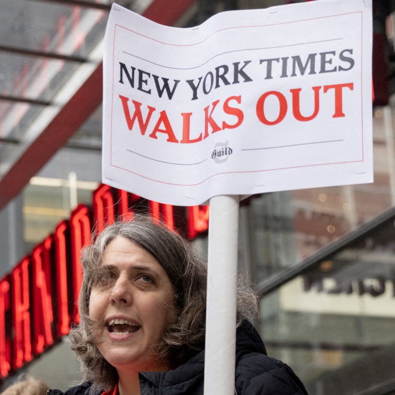 A guild member holds a placard supporting a union walk out, outside the New York Times building in Manhattan on Thursday. Photo: Reuters