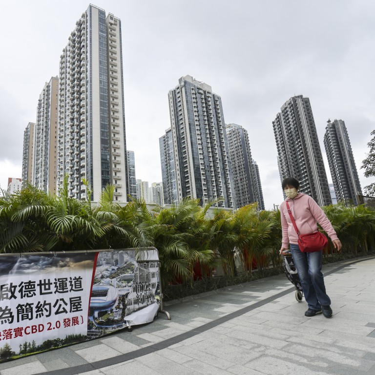 People walk past a banner protesting against the government plan to build “light public housing” near a middle-class neighbourhood in Kai Tak’s new development area, in Kowloon, Hong Kong on February 8. Photo: May Tse
