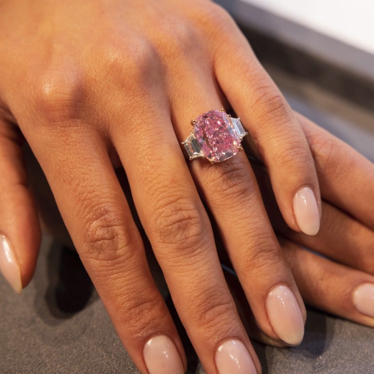 A woman displays the 10.57 carat Eternal Pink diamond at Sotheby’s, on March 27, in New York. Photo: AP Photo