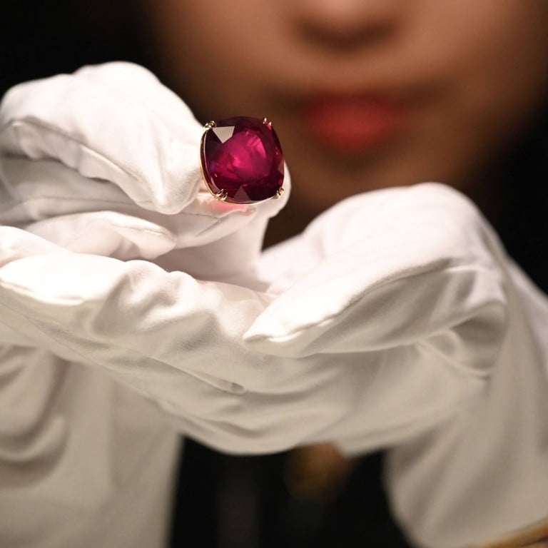 A representative from Sotheby’s Hong Kong holds up the Estrela de Fura Ruby in Hong Kong on April 17. Photo: AFP