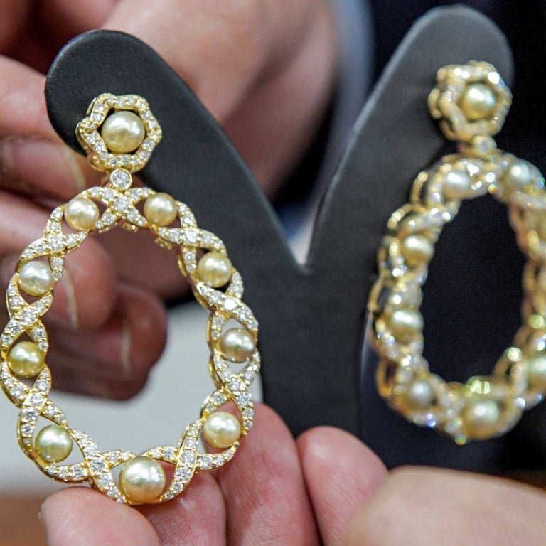 A jeweller displays natural pearl earrings at the House of Pearls shop in Manama, on February 2. Photos: AFP