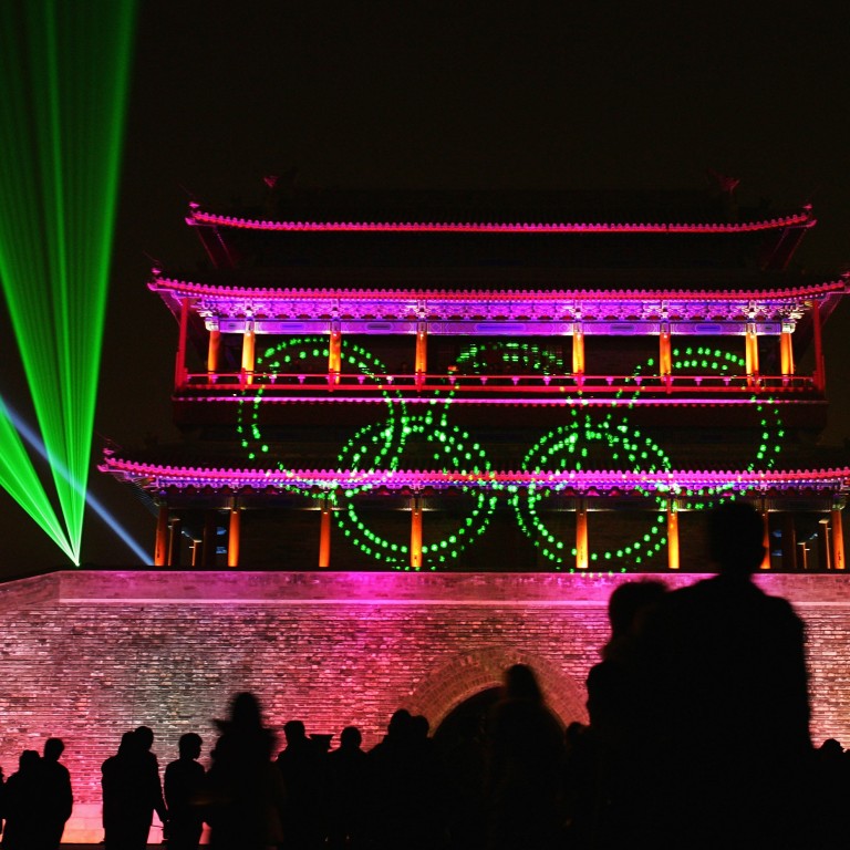 Visitors look at a laser performance in front of the Yongdingmen, or central south gate, in Beijing, rebuilt in 2003. The city is seeking Unesco World Heritage status for a large area of its former imperial inner city, including this gate. Photo: Getty Images