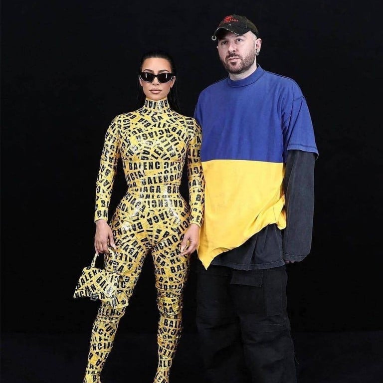 Balenciaga creative director Demna Gvasalia showing his true colours: pictured with a fully branded Kim Kardashian and wearing a T-shirt in the colors of the Ukrainian flag, at the Balenciaga fall/winter 2022-23 fashion show in Paris-March 2022. Photo: Instagram