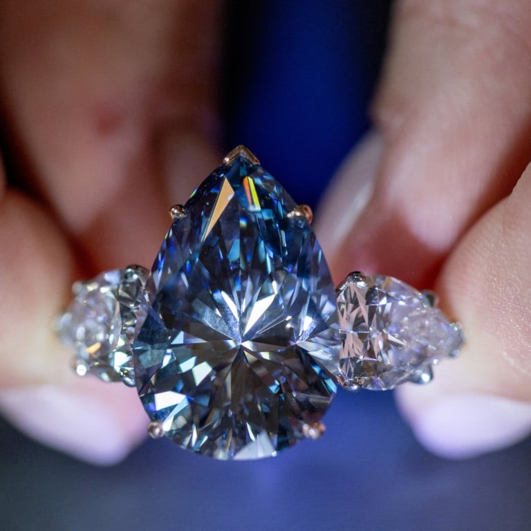 A Christie’s auction house staff member holds the Bleu Royal diamond, weighing 17.61 carats, which is the largest to appear for sale in auction history and that could sell for up to US$50 million, during an auction preview in Geneva, Switzerland, on November 1. Photo: Reuters