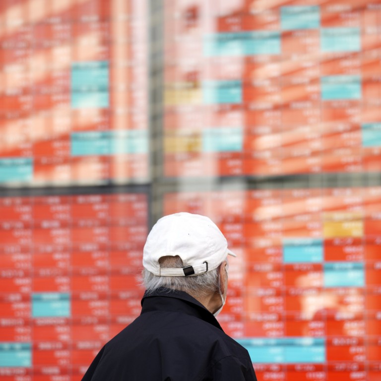 A man looks at an electronic stock board showing Japan’s Nikkei 225 index on January 22 in Tokyo. While Japanese stock prices are up 60 per cent from six years ago, real GDP has risen just 1 per cent. Photo: AP