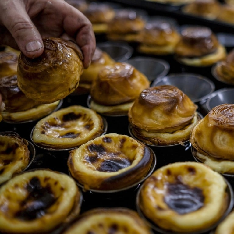 Cooked pasteis de nata are taken out of trays at the Pasteis de Belem cafe in Lisbon, Portugal. The pastel de nata, which means cream pastry in Portuguese, has become an international hit, centuries after it was supposedly invented in a Belem monastery by monks. Photo: Bloomberg
