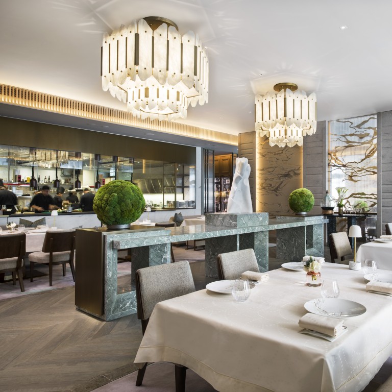 The interior of L'Envol at the St. Regis Hong Kong, which features a stunning, central screen with a hand-painted silk covering.