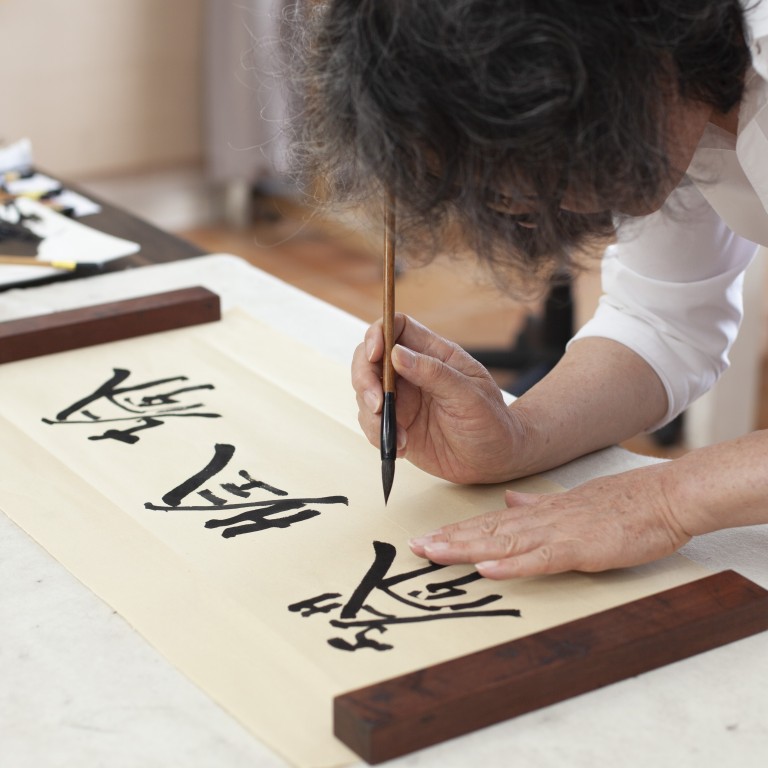 Chinese artist Xu Bing works on his distinctive art for Shanghai Tang, the luxury fashion brand which this year celebrates its 25th anniversary.