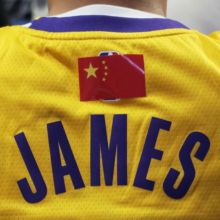 Following the anti-NBA fallout, a fan is seen wearing a LeBron James jersey with the NBA logo covered by a Chinese national flag, during a match between the Los Angeles Lakers and Brooklyn Nets at Shanghai’s Mercedes-Benz Arena, on Thursday, October 10. Photo: Reuters