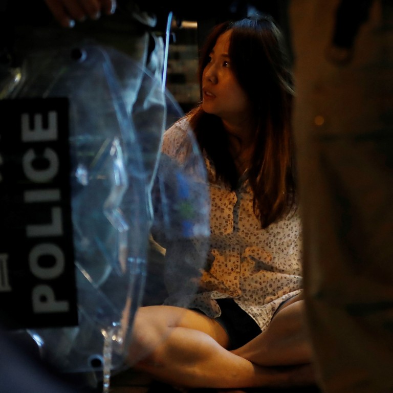 A woman is detained by riot police after Wednesday night’s unrest in Tuen Mun. Photo: Reuters