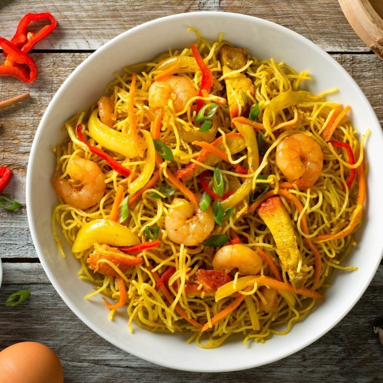 Delicious Singapore-style noodles, comprising curry, shrimp, barbecued pork, carrots, red pepper, onion and scallions, doesn’t come from its purported country of origin.