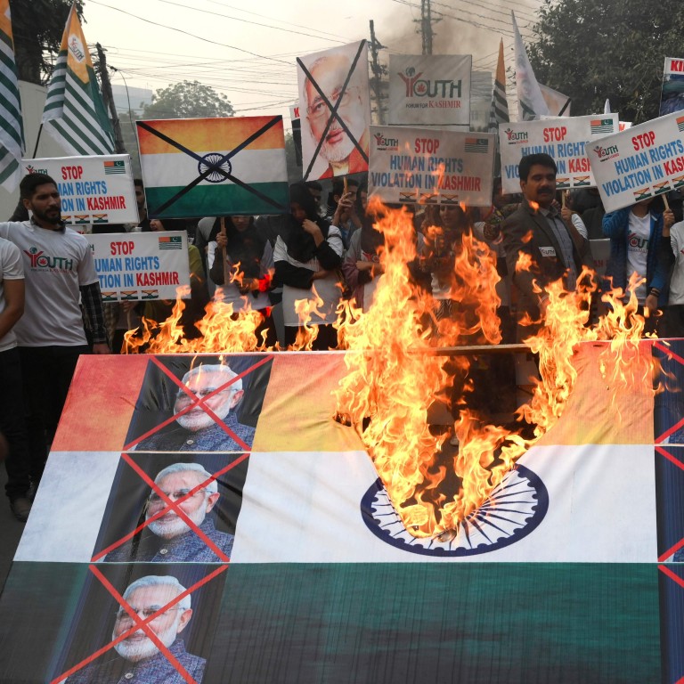 Activists of the Youth Forum for Kashmir burn an Indian flag with pictures of Indian Prime Minister Narendra Modi on Human Rights Day. Photo: AFP