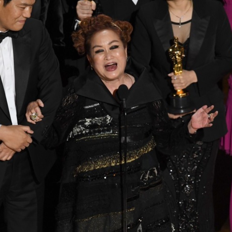 Parasite’s executive producer Miky Lee celebrates on the Oscars stage after the film wins best picture. Photo: Getty Images