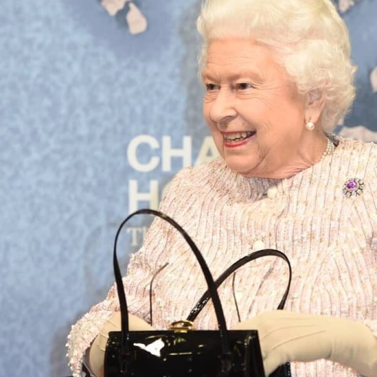 Queen Elizabeth sits with Sir David Attenborough – holding her favourite black patent Launer bag. Photo: launerlondonofficial/Instagram