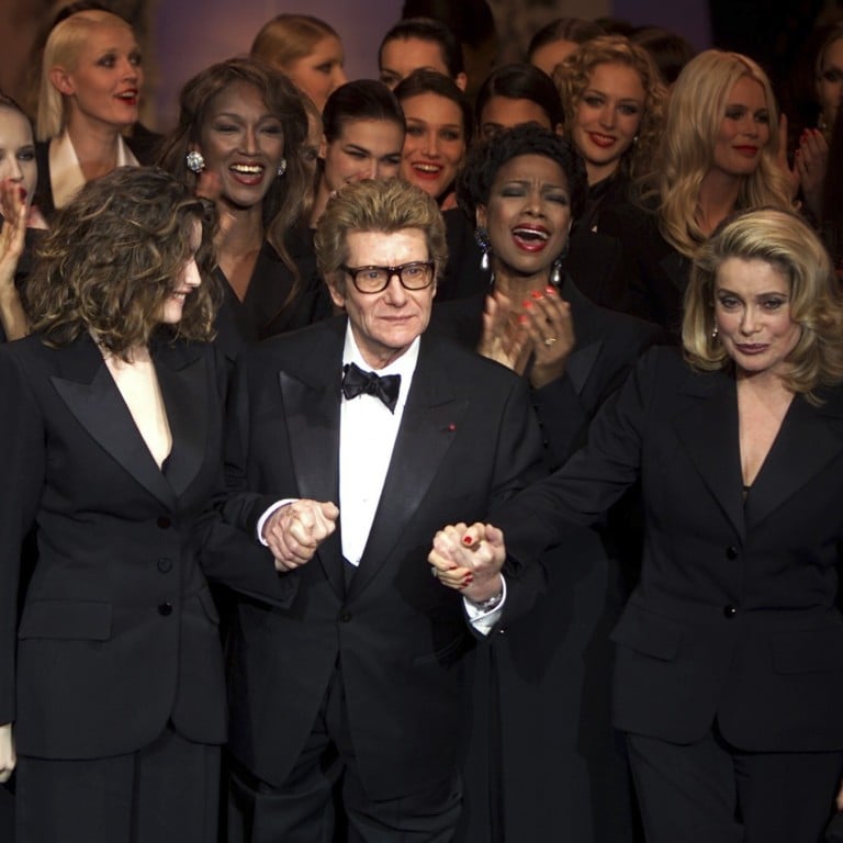 Yves Saint Laurent with model Laetitia Casta (left) and actress Catherine Deneuve at his retrospective in Paris in January 2002. Photo: Reuters/Philippe Wojazer/Files (France)