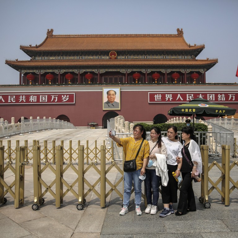 Tourists take a selfie in front of the Tiananmen Gate in Beijing. China is loosening up nationwide travel restrictions after months of lockdown over the coronavirus crisis. Photo: EPA-EFE
