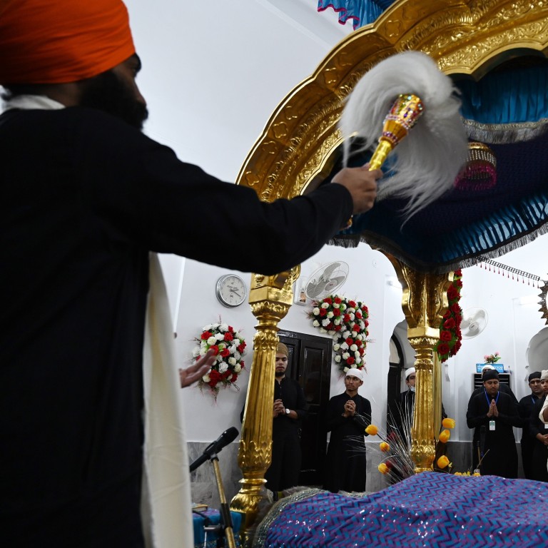 Sikh pilgrims take part in a religious ritual on the occasion of the 481st death anniversary of Guru Nanak, the founder of Sikhism, at Gurdwara Darbar Sahib in Kartarpur, near the India-Pakistan border on Tuesday. A travel corridor created last year to let Indian Sikhs visit the holy shrine in northeast Pakistan remains closed on the sacred day. Photo: AFP