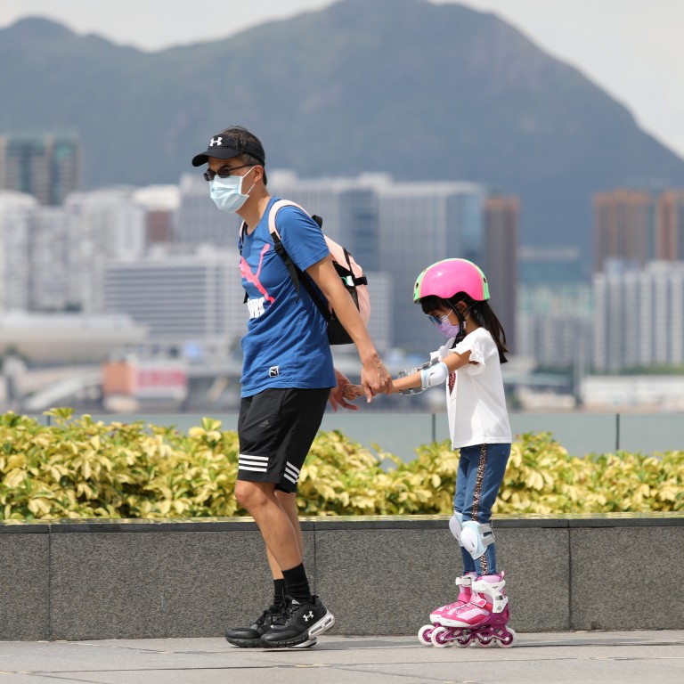 A man pulls along a girl on rollerblades at Tamar Park in Admiralty, Hong Kong, on August 10. Hong Kong has relaxed measures to contain the spread of Covid-19, but some restrictions remain. Photo: Nora Tam