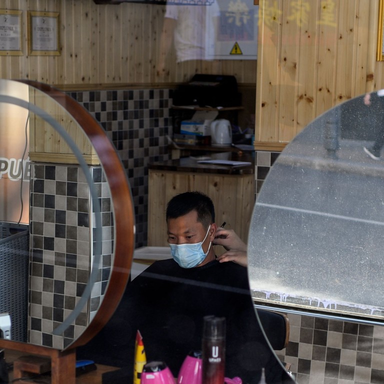 A man gets a haircut in Madrid, Spain. Residents will be barred from leaving except on essential trips under new rules to fight the coronavirus resurgence. Photo: AFP