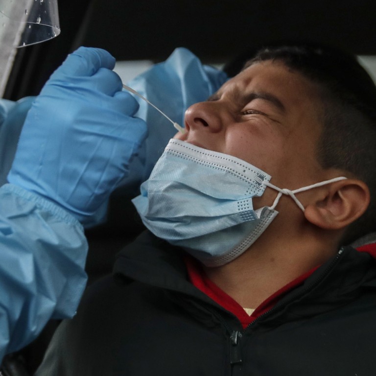 A medical worker takes a swab as she tests a boy for Covid-19 at a hospital in Milan, Italy on Thursday. Photo: AP