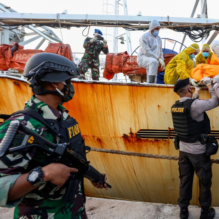Indonesian police removing the body of an Indonesian crew member who was killed on board a fishing vessel off Batam Island in July. Photo: AFP