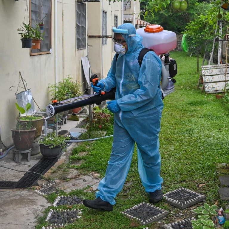 A worker sprays disinfectant in the backyard of a building in Kuala Lumpur. Photo: AFP