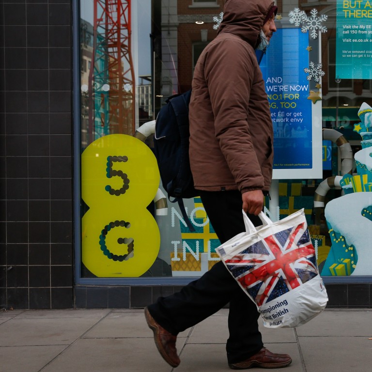 A pedestrian passes an EE store advertising 5G network capabilities in London, U.K., on Tuesday, Nov. 24, 2020. The U.K. is considering a ban on the installation of Huawei Technologies Co. 5G equipment as soon as next year to appease hawks pushing for tighter restrictions on the Chinese network equipment maker, according to people familiar with the matter. Photographer: Hollie Adams/Bloomberg
