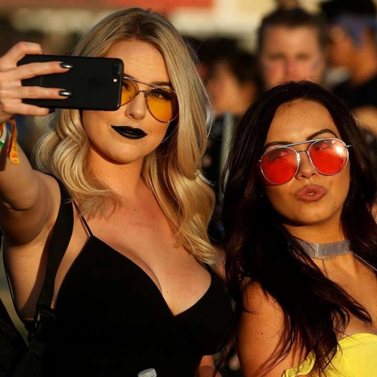 Women fans take a photo in the late afternoon sun during the Coachella Festival in California. Photo: Reuters