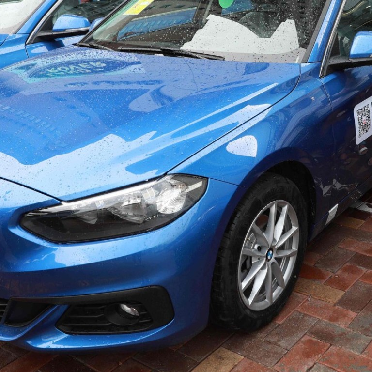 A man scans a QR code on a BMW 1-Series ‘sharing car’ in Shenyang, China. Photo: AFP