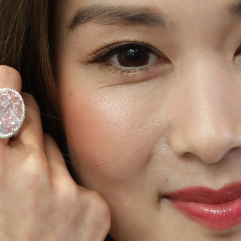 The Pink Promise, a 14.93ct fancy vivid pink diamond ring, estimated to sell for HK$220 million to HK$320 million, modelled by actress Eliza Sam.