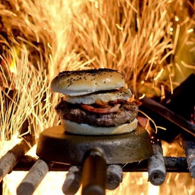 A hamburger is cooked by wood-fuelled fire at Kon Kon restaurant in Buenos Aires, Argentina. Photo: AP