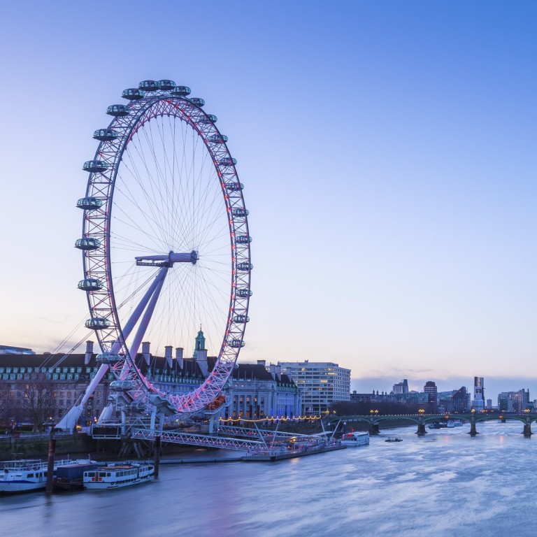 Skyline of London before sunrise with famous landmarks, Big Ben, Houses of Parliament, boats and a clear blue sky.