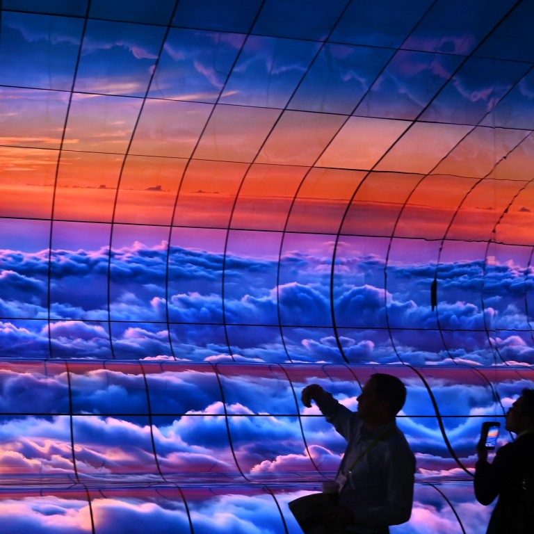 People take photographs of the ‘Massive Curve of Nature’ display, featuring 250 curved LG organic light-emitting diode television screens at last week’s consumer electronics show in Las Vegas, CES 2019, last Friday. Photo: AFP