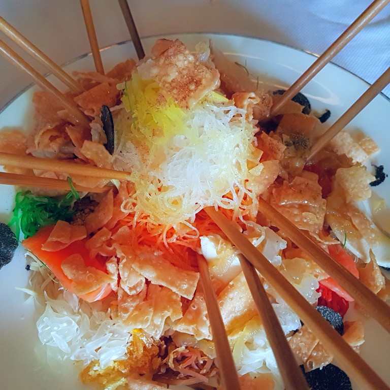 Long chopsticks poised to stir up some good fortune in a dish of yee sang laden with good luck ingredients at Cassia, Capella Singapore. Photos: Cedric Tan