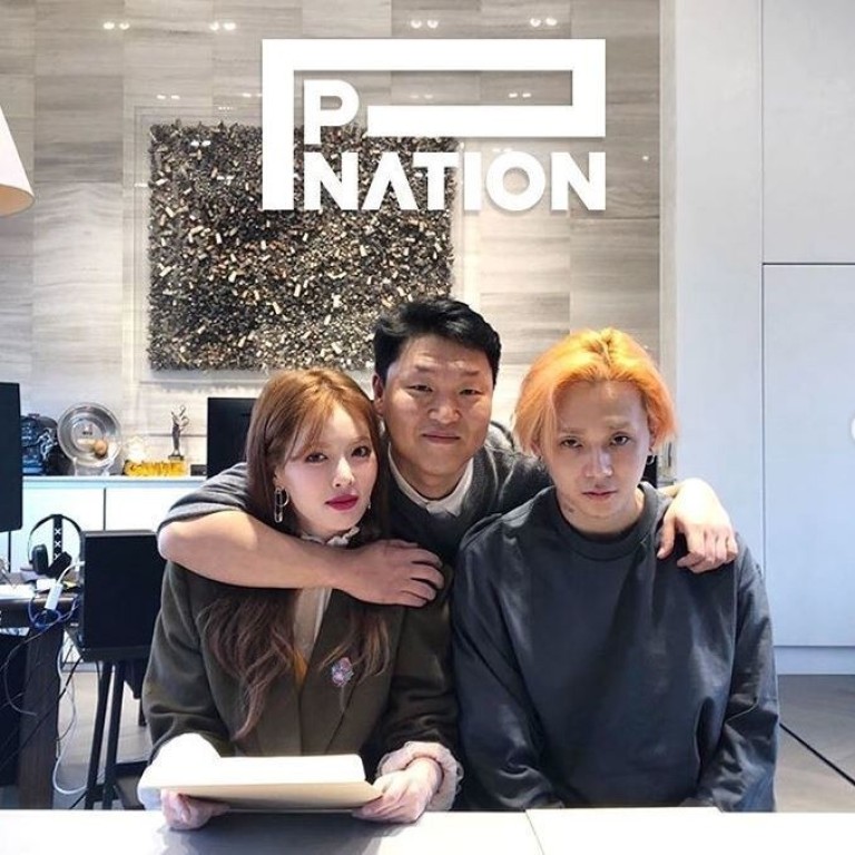 PSY (middle), with HyunA, left, and E’Dawn who signed a contract with his label, P NATION. Photo: PSY’s Instagram.