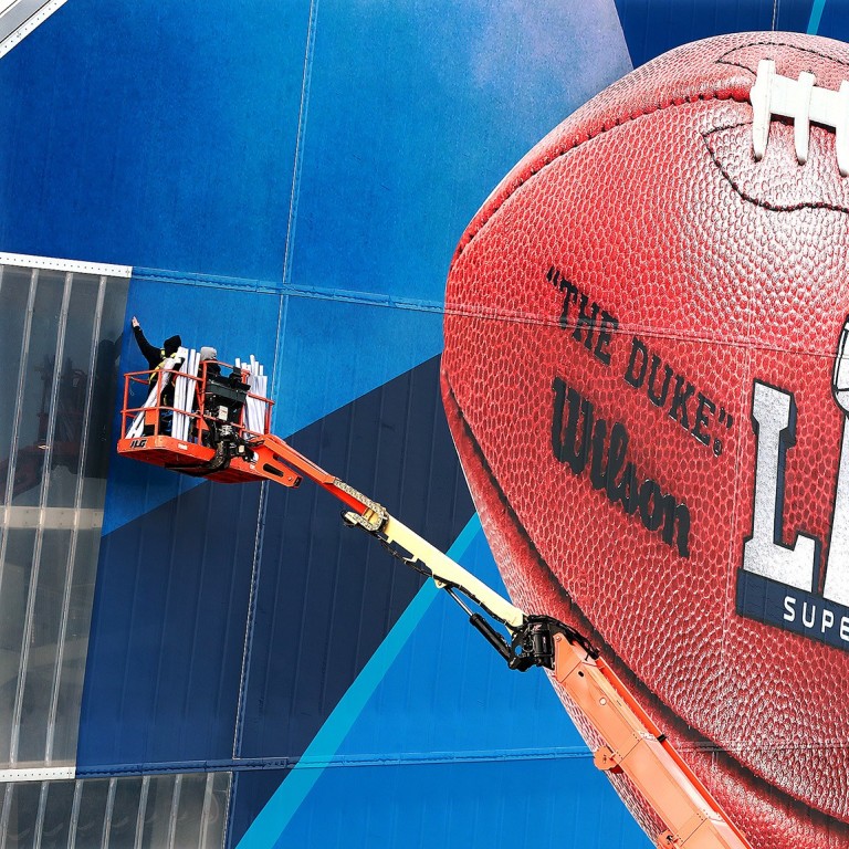 Workers use a lift to install a Super Bowl LIII advertisement at Mercedes-Benz Stadium in Atlanta, Georgia ahead of the big game. Photo: Atlanta Journal-Constitution/TNS