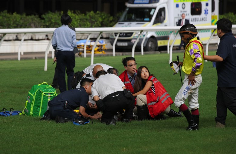 Karis Teetan (right) limps away from Wednesday night’s horror Happy Valley fall, while Jerry Chau is treated on the track. Photo: Kenneth Chan