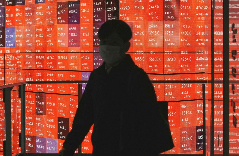 A man walks past an electronic board displaying the Nikkei 225 stock prices on the Tokyo Stock Exchange in Tokyo on January 5. Photo: AFP