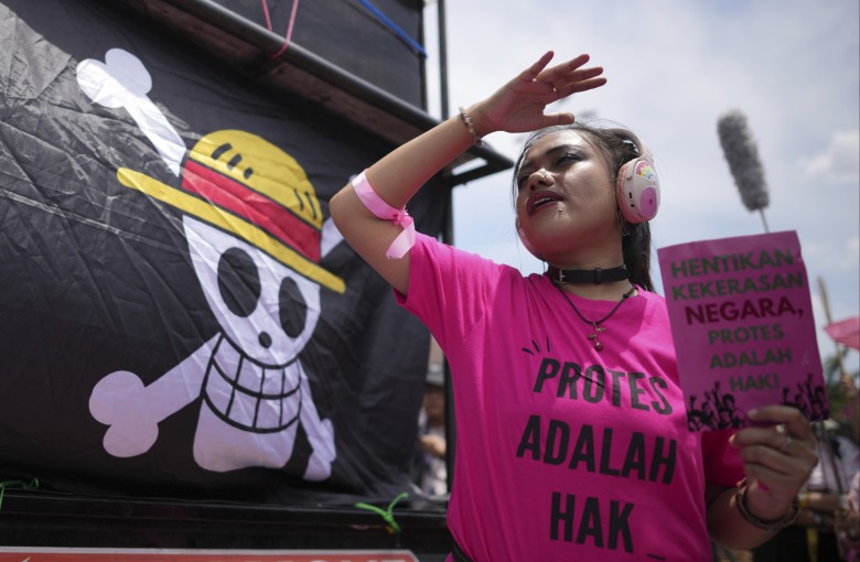 An activist holds a poster next to a flag bearing an image of the “Jolly Roger” from popular Japanese anime “One Piece” during a protest in Jakarta, Indonesia, in September. Photo: AP
