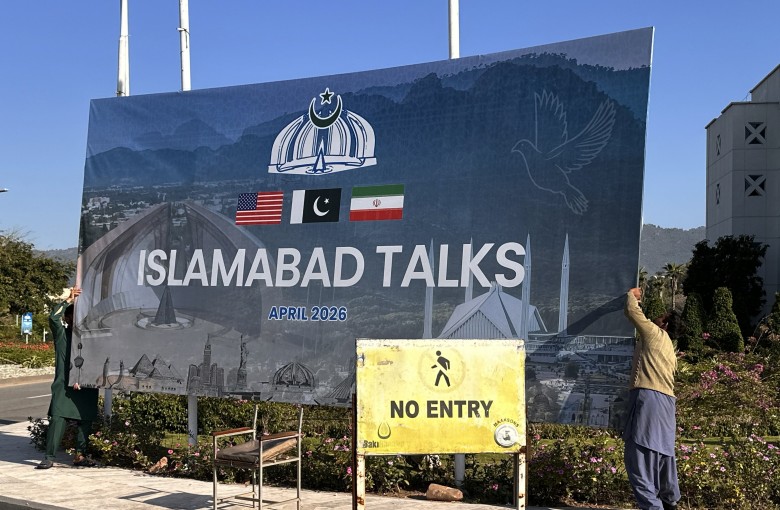Workers remove a billboard after the failed peace talks between the United States and Iran, in Islamabad, Pakistan, on April 12. Photo: EPA