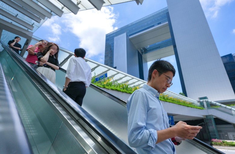 Civil servants and others ride an escalator near the government’s headquarters in Tamar, Admiralty, on May 28. Photo: Karma Lo