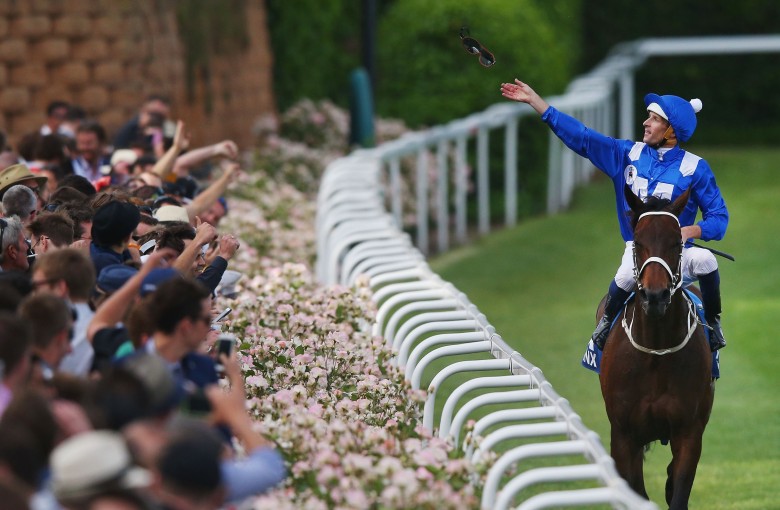 Hugh Bowman throws his goggles into the crowd after winning the 2015 Cox Plate with Winx. Photo: Michael Dodge/Getty Images